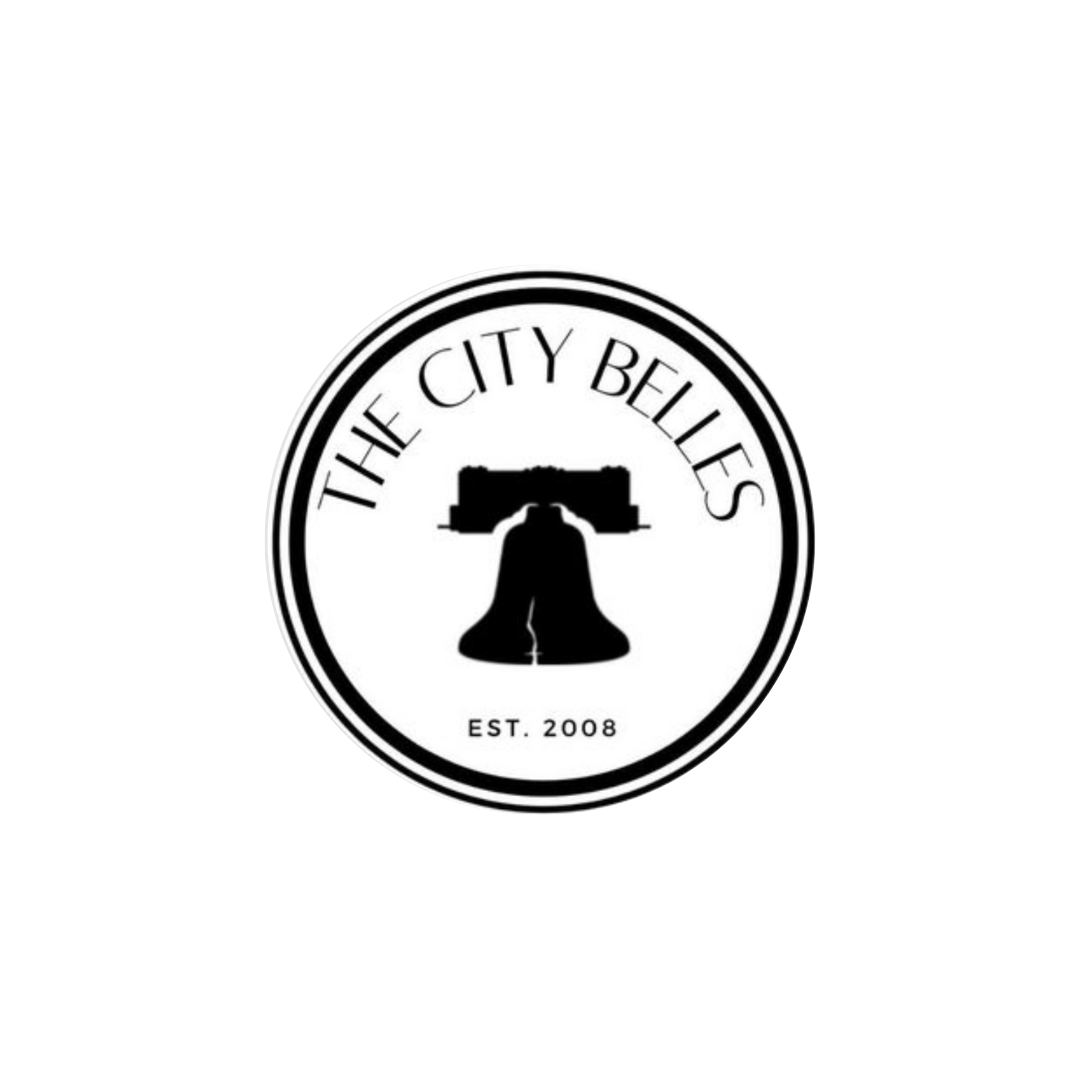 circle logo that has an image of the liberty bell in black with the words: the city belles.